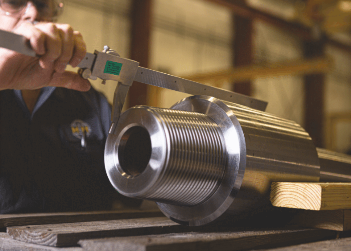 M&M International employee measuring a pipe